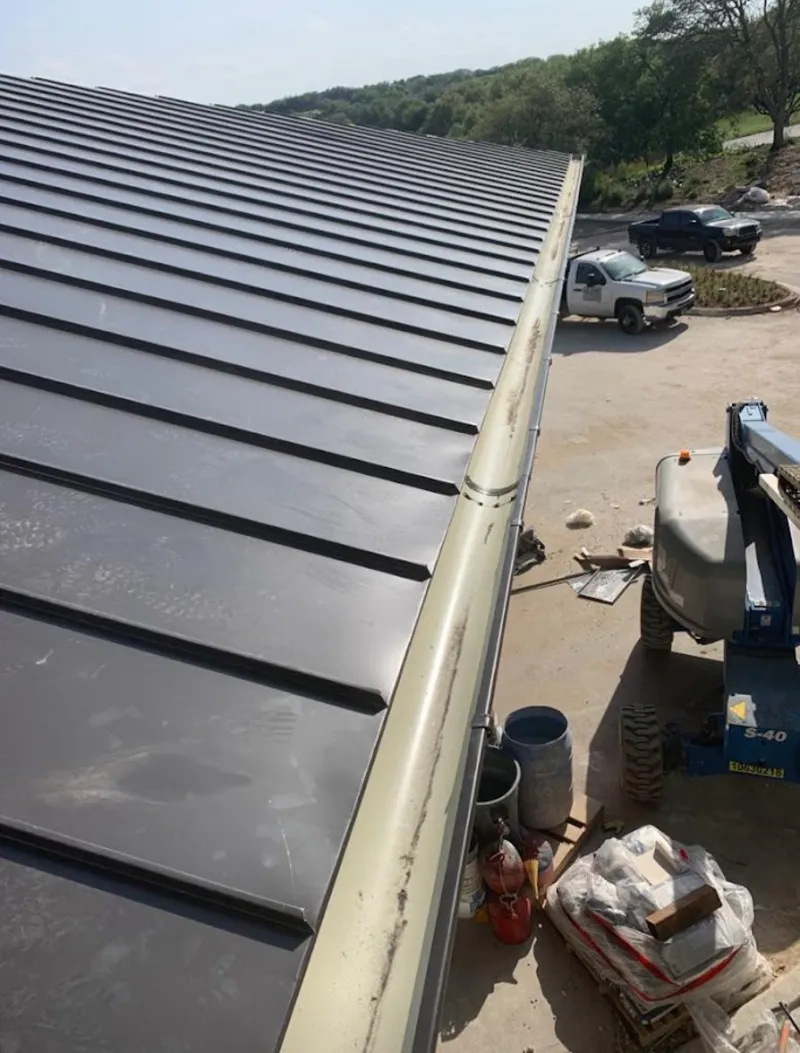 Standing seam panel and gutter detail on a metal roofing jobsite in Putnam